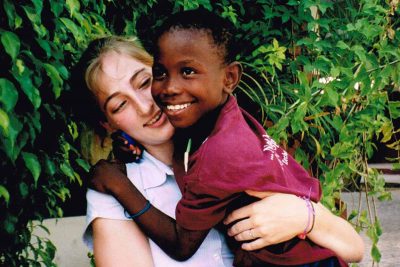 Abby hugging a smiling boy.