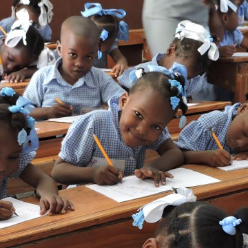 Preschool girl looking up in class and smiling.